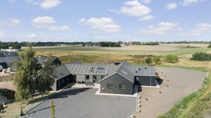 A large building with a flat roof, surrounded by open fields and a clear sky. - VillaVilla 966 - Marielyst, Lolland/Falster/møn (Idestrup)