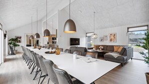 A modern interior with a long dining table, grey sofas, and pendant lighting. - VillaVilla 966 - Marielyst, Lolland/Falster/møn (Idestrup)
