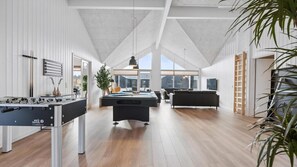 A spacious room with a foosball table, pool table, and a large window providing a view of the outdoors. - VillaVilla 966 - Marielyst, Lolland/Falster/møn (Idestrup)
