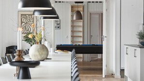 A modern kitchen with a dining area, featuring a pool table, pendant lights, and a white cabinet. - VillaVilla 961 - Marielyst, Lolland/Falster/møn (Idestrup)