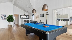 A pool table in a modern living room with a kitchen and dining area in the background. - VillaVilla 961 - Marielyst, Lolland/Falster/møn (Idestrup)