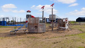 A playground with various play structures including a slide, climbing frames, and a small tower. - VillaVilla 915 - Skåstrup Strand, Fyn og øer (Bogense)