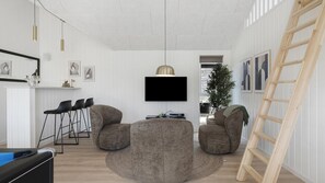 Uma sala de estar moderna com uma TV de tela plana na parede, dois pufes, uma mesa de centro pequena e uma escada de madeira encostada na parede.