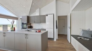 Eine moderne Küche mit einer großen Kochinsel, einem Einbauofen und einem Kühlschrank.