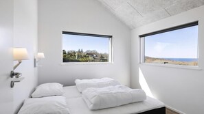 A bedroom with two windows, a bed with white bedding, and wall-mounted lamps. - VillaVilla 927 - Hasle, Bornholm (Hasle)