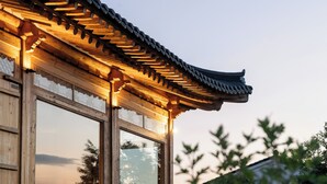 A traditional wooden building with a curved roof and large windows.