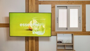 Ein Fernsehbildschirm mit dem Wort 'essential' und ein Glas Wasser mit Orangenscheibe.