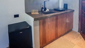 Une cuisine compacte avec des meubles en bois, une cuisinière encastrée et un petit réfrigérateur.