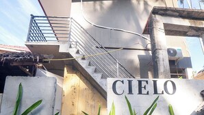 Un bâtiment avec une enseigne indiquant « Cielo », un escalier et quelques plantes devant.