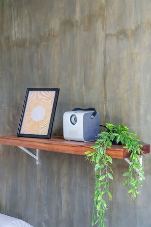 A wooden shelf with a framed picture, a vintage radio, and a potted plant against a concrete wall. - CIELO 1 - steps away from beach, Cloud 9 Siargao (General Luna)