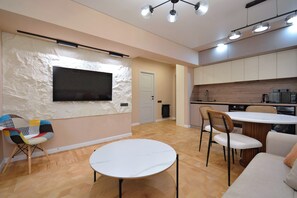 Eine moderne Küche mit Holzausstattung, einem Einbauofen und einem Essbereich mit rundem Tisch und Stühlen.