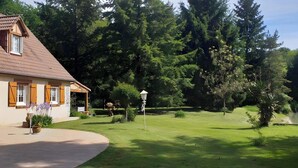 A house with a sloped roof, wooden shutters, and a garden with a pond. - Bed and Breakfast 'Chambre Quadruple' with Shared Pool, Shared Terrace and Wi-Fi (Chitenay)
