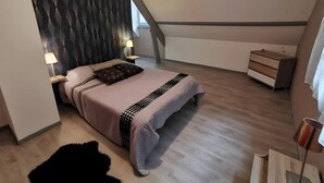 A modern bedroom with a bed, bedside lamps, a dresser, and a geometric-patterned wall. - Bed and Breakfast 'Chambre Quadruple' with Shared Pool, Shared Terrace and Wi-Fi (Chitenay)