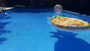 A swimming pool with a tiled floor, a floating pineapple-shaped inflatable, and a clear plastic ball. - Bed and Breakfast 'Chambre Quadruple' with Shared Pool, Shared Terrace and Wi-Fi (Chitenay)