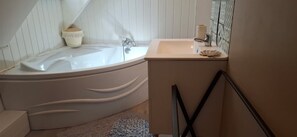 Un baño con bañera, lavamanos y espejo.
