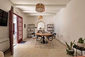 A dining area with a round table, chairs, and a hanging light fixture. - La Corte Bella (Leverano)