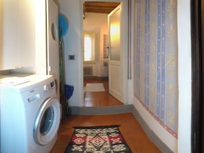 A laundry area with a washing machine, a blue basin, and a patterned rug. - I Tre Camini by Interhome (Montieri)