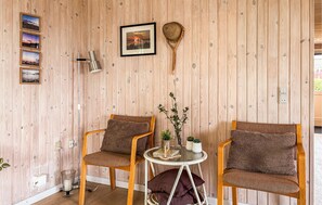 A wooden-paneled room with two wooden chairs, a small table, and a framed picture on the wall. - Gorgeous home in Hejls with WiFi (Hejls)