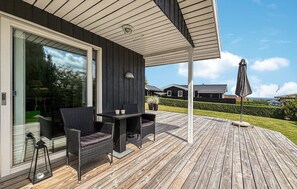 A covered outdoor area with wicker furniture, a table, and an umbrella. - Gorgeous home in Hejls with WiFi (Hejls)