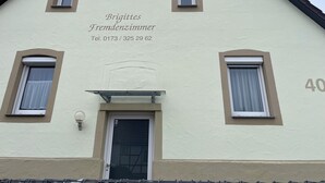A two-story building with a beige facade, numbered 40, and a sign indicating 'Brigitte Fremdenzimmer' with a telephone number. - Brigittes Fremdenzimmer (Leonberg)