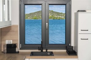 Ein Zimmer mit Seeblick, einer schwarzen Tür, einem weißen Schrank und einer Kaffeestation.