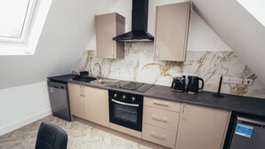 A modern kitchen with a built-in oven, a dishwasher, and a black range hood.