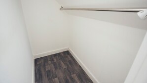 A corner of a room with a wooden floor, white walls, and a white ceiling.