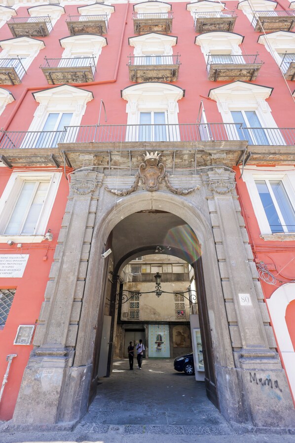 Una entrada arqueada a un edificio con múltiples ventanas y balcones.