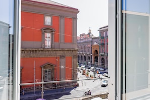 Vista de una calle con edificios históricos, cielo despejado y algunos peatones.