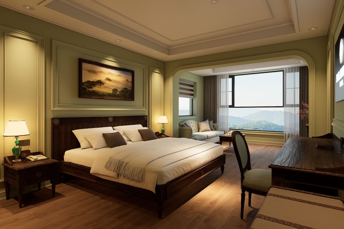 A hotel room with a large bed, a desk, a chair, a painting on the wall, and a view of the mountains.