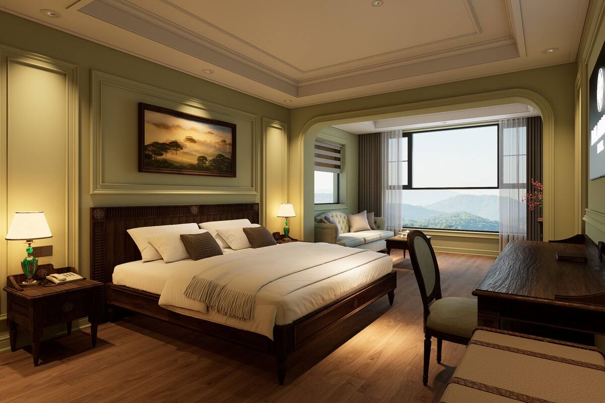 A hotel room with a large bed, a desk, a chair, a painting on the wall, and a view of the mountains.