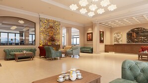 A spacious lobby with a high ceiling, elegant furniture, and a large window offering a view.