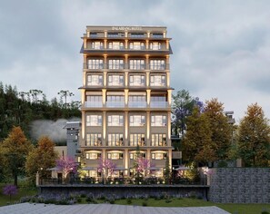 A multi-story hotel with a modern design, featuring balconies and a stone facade. - Dalabiang Hotel (Da Lat)