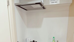 A compact kitchen with a sink, a stove, and a dish rack. - Dc Sakura Hotel - Tenjin Beppu (Osaka)