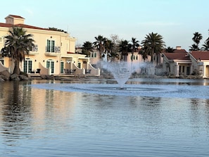 A water fountain in a courtyard with palm trees and buildings in the background. -  Sunset Beach Resort for Entertainment (Eastern Province)