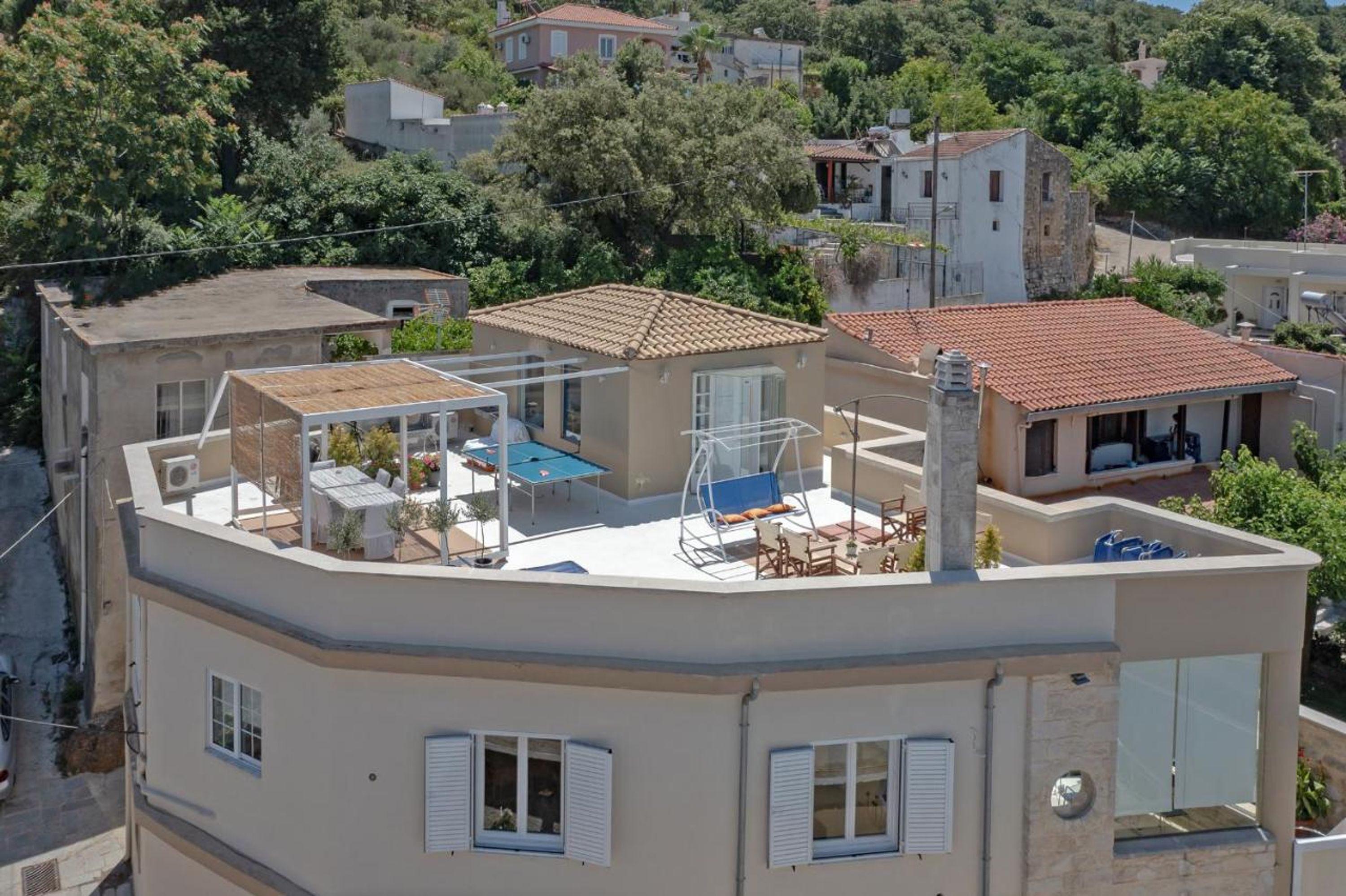 A residential building with a rooftop terrace, a swimming pool, and a covered outdoor seating area.