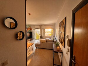 Eine moderne Wohnung mit Küche, Wohnbereich und einem Balkon mit Blick auf die Stadt.