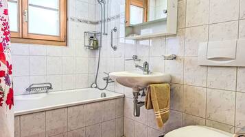 A bathroom with a bathtub, sink, and toilet.