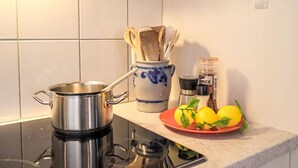 Eine Küche mit Herd, Topf, Gewürzregal und einem Teller mit Zitronen.