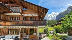 Eine Holzchalet mit Balkon, Sitzgelegenheit im Freien und Bergblick.