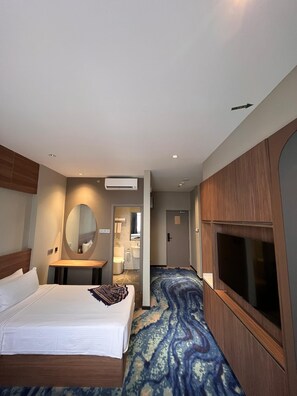 A hotel room with a bed, a TV, a mirror, and a bathroom visible through an open door. - BRISDALE INTERNATIONAL KUALA LUMPUR (Kuala Lumpur)