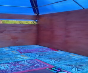 Una habitació amb sostre i parets blaus, un terra amb dibuixos i una finestra ben visible.