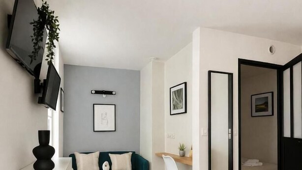 Ein modernes Wohnzimmer mit einer Couch, einem Couchtisch, einem Fernseher und einem Schreibtisch mit Stuhl.