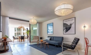 A modern living room with a sofa, a coffee table, a chair, and artwork on the wall. - Casa Sonnenberg | Sea View - Pool - Terrace (Fuengirola)