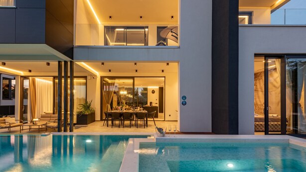 A modern two-story house with an outdoor swimming pool, a dining area, and a visible bedroom. - Villa Marro Zadarvillas (Privlaka)
