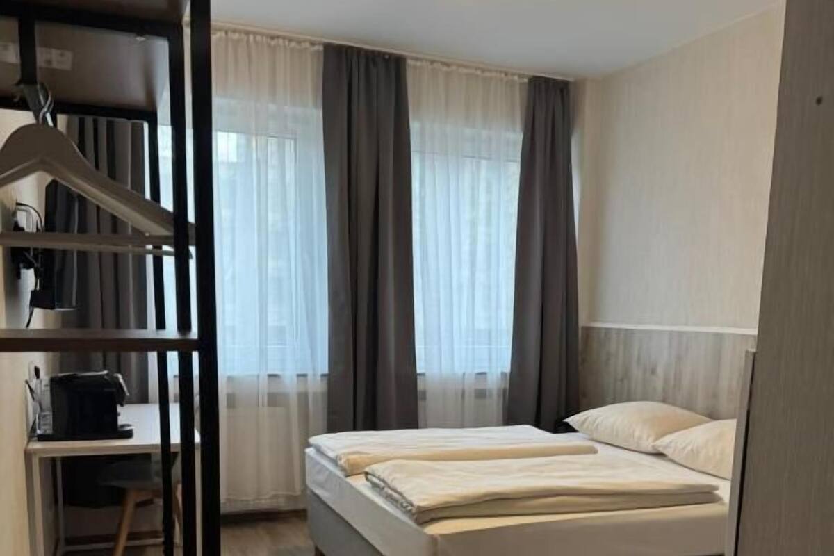 Un dormitorio con cama, escritorio y armario.