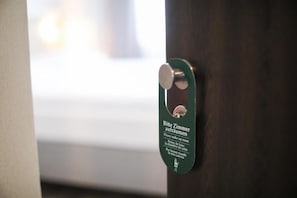 A door with a metal handle and a green sign with text in multiple languages.