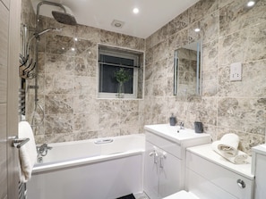 A modern bathroom with a bathtub, a sink, and a mirror.