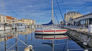 Un puerto deportivo con barcos amarrados, un edificio con un letrero y una bicicleta.