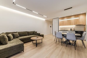 Un saló modern amb un sofà, taula de centre i zona de menjador amb cadires.